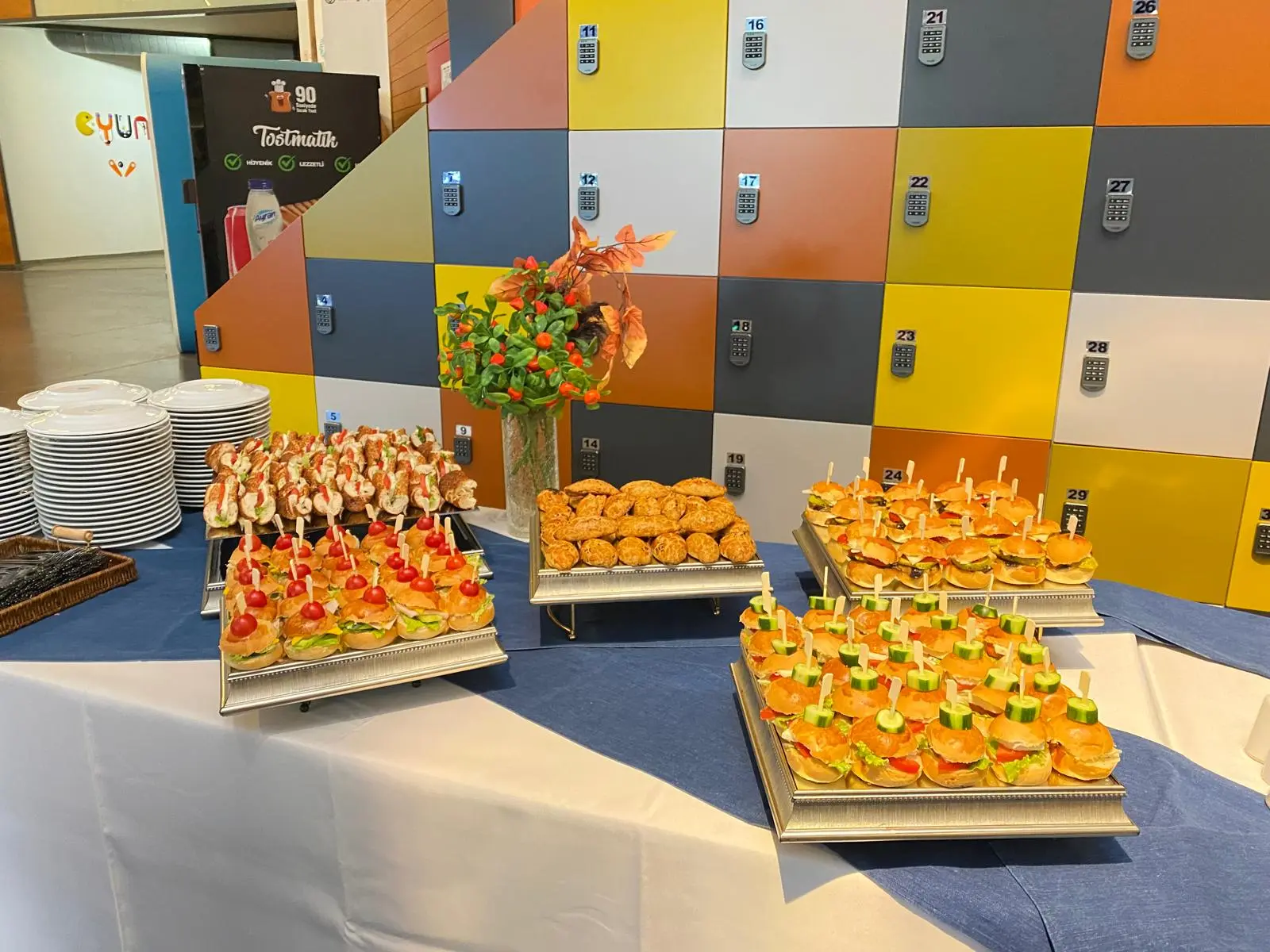Kurumsal etkinlikte renkli dekor önünde finger food büfesi